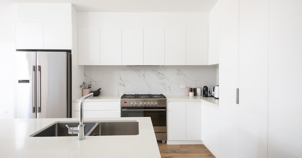 Minimalist white wooden cabinets over a clean and organized kitchen countertop